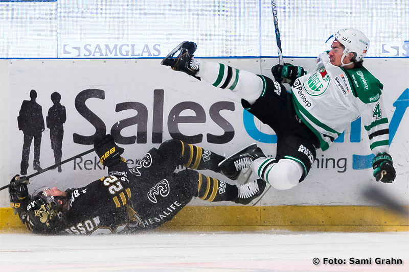 En liggande AIK 22 Daniel Josefsson bjuder Rögle 4 Nils Bergström på en flygtur