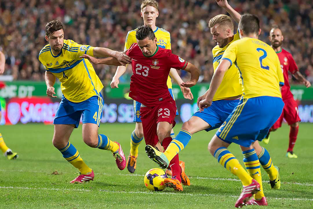 Sverige Per Nilsson, Rasmus Elm, Sebastian Larsson och Mikael Lustig försöker stoppa Portugal Hélder Postiga 